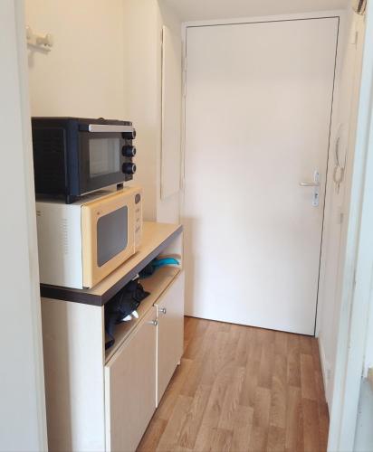 - un four micro-ondes installé au-dessus d'un comptoir dans l'établissement logement calme proche de paris, à Créteil