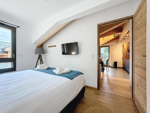 une chambre avec un lit et une télévision au mur dans l'établissement Les 3 Mousquetons-appartement-6-8 Pers-Proche centre, aux Gets