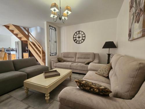 a living room with two couches and a table at L'Abaca 27 in Sainte-Geneviève-lès-Gasny