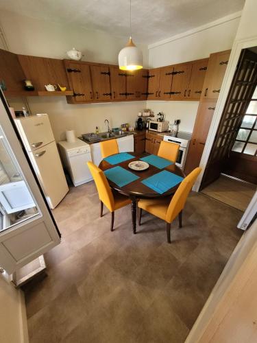 une cuisine et une salle à manger avec une table et des chaises dans l'établissement La Salamandre -appartement, à Salbris