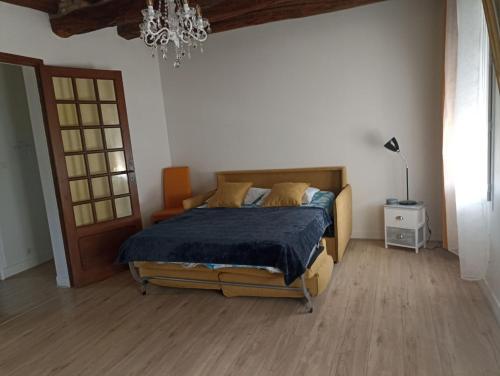 une chambre avec un lit et un lustre dans l'établissement La Salamandre -appartement, à Salbris
