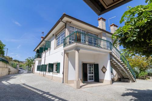 an old house with a balcony and a staircase at Quinta do Fontanário by LovelyStay in Celorico de Basto