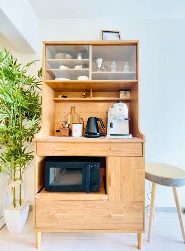 a wooden cabinet with a microwave inside of it at Alo BnB 14 - Cats and Coffee - Near Shibuya ! Self check-in in Tokyo