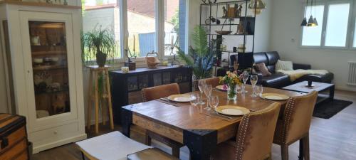 une salle à manger avec une table et des chaises en bois dans l'établissement Maison de ressourcement au calme, à Beuvry