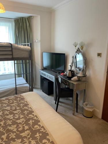 a bedroom with a desk with a mirror and a bed at Keats Green Hotel in Shanklin