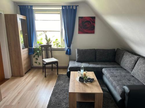 a living room with a couch and a table at Ferienwohnung Winzenburg Naturnah und ruhig gelegene Ferienwohnung nah am Steinhuder Meer und Dino Park Münchehagen in Rehburg-Loccum