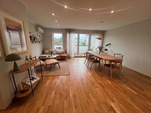 a living room with a table and a dining room at Large apartment close to ONS in Madla