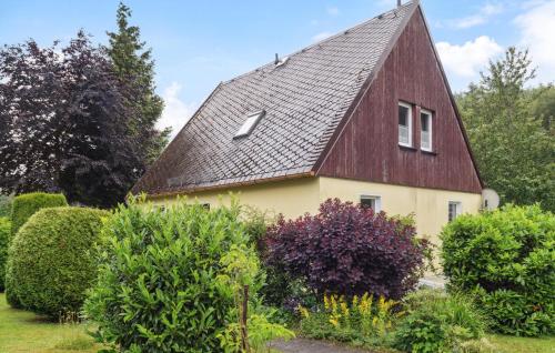 a house with a gambrel roof in a garden at Cozy Home In Bad Brambach With Sauna in Bad Brambach