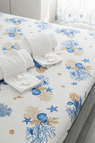 a bed with a blue and white comforter at B&B VistaMare in Civitavecchia