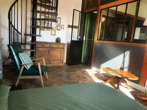 une chambre avec un lit, une chaise et une table dans l'établissement Cosy appart, à Saint Etienne