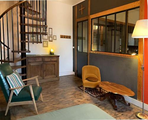 un salon avec une table et des chaises et un escalier dans l'établissement Cosy appart, à Saint Etienne
