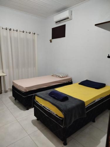 a room with two beds in a room with a tv at Quarto individual com 2 camas box de solteiro hostel 940 in Sinop