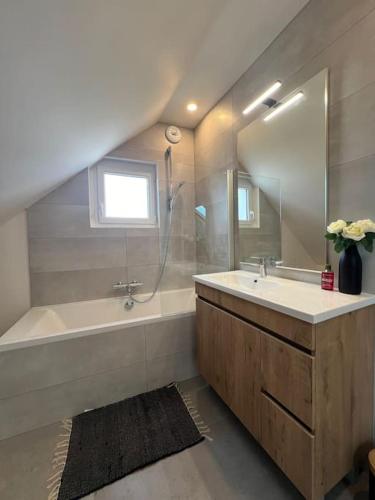 une salle de bain avec un lavabo, une baignoire et un miroir dans l'établissement Ty-Kern, à Riantec