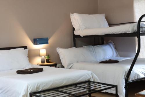 a room with two bunk beds and a lamp at The Ultimate Lodge in Louis Trichardt