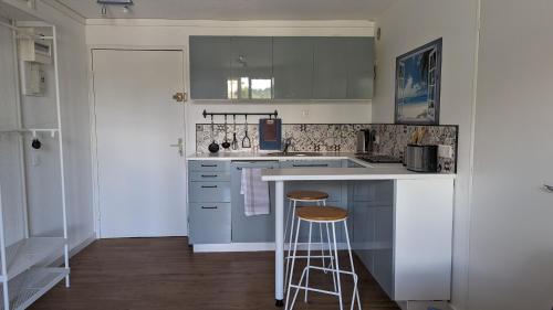 une cuisine avec un comptoir et deux tabourets de bar dans l'établissement appartement proche mer, à La Seyne-sur-Mer