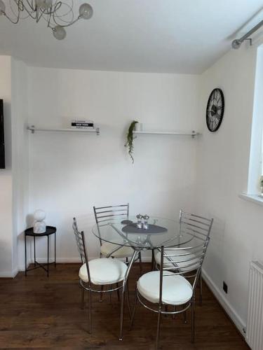 a dining room with a table and chairs and a clock at Home in Greater Manchester in Middleton