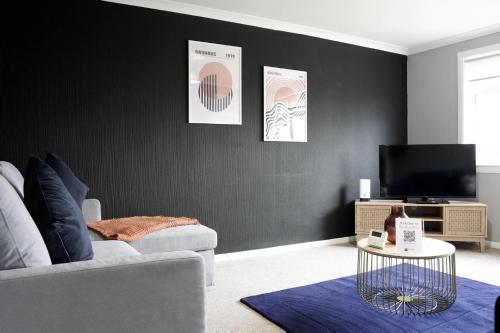 a living room with a couch and a tv at Barclay House in Livingston