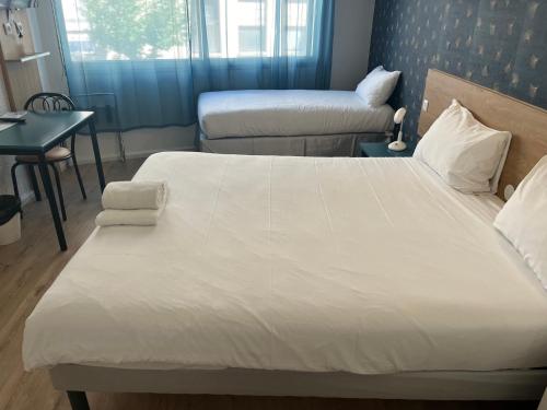 a bedroom with a large white bed and a desk at greet hotel Grenoble Centre Gare in Grenoble