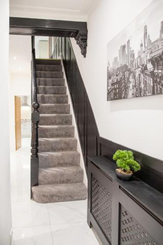 a staircase in a house with a picture on the wall at Entire Luxury Home in Old Trafford, next to MUFC in Manchester