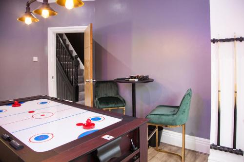 a room with a ping pong table and chairs at Entire Luxury Home in Old Trafford, next to MUFC in Manchester