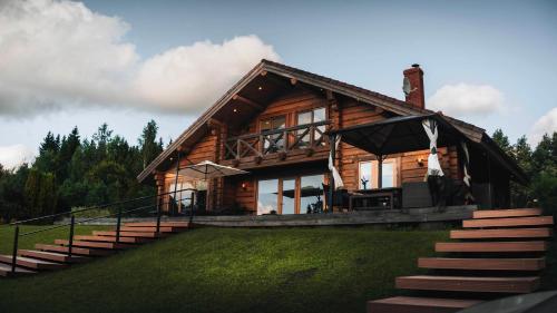 a log cabin with stairs leading up to it at Bērzi in Turkalne