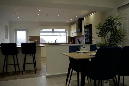 une cuisine avec une table et des chaises dans une cuisine dans l'établissement 2 BDR House At Caledonia Luxe Stays Short Lets & Serviced Accommodation Lanark, à Lanark
