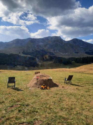 a fire pit in the middle of a field with two chairs at The View Smrcevo Brdo in Žabljak
