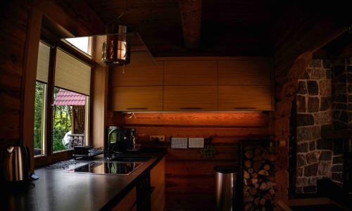a kitchen with wooden cabinets and a sink and a window at Bērzi in Turkalne