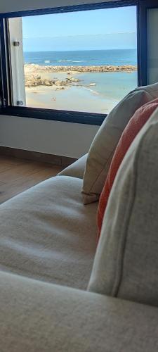 a bedroom with a bed with a view of a beach at Burela Mariña Playa in Burela de Cabo