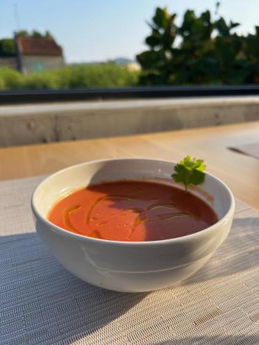 a bowl of soup sitting on a table at Hôtel La Petite Bohème in Le Lavandou