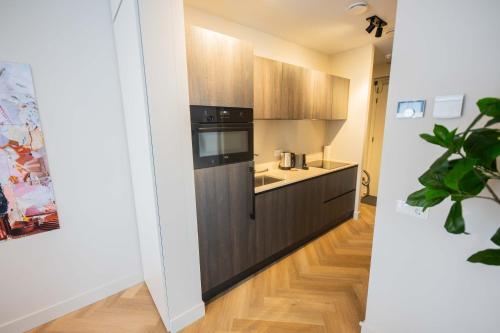 a kitchen with black appliances and wooden cabinets at Kerkstraat in Hilversum