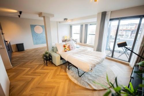 a living room with a bed and a large window at Kerkstraat in Hilversum