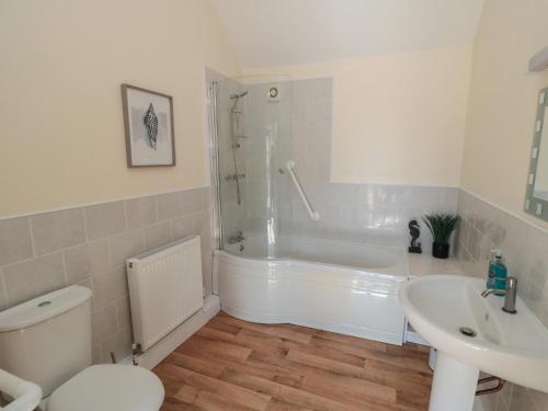 ein Badezimmer mit Badewanne, Toilette und Waschbecken in der Unterkunft Curlew Cottage in Filey
