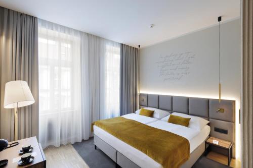 a bedroom with a large bed and a large window at Hotel Prokop Square in Prague