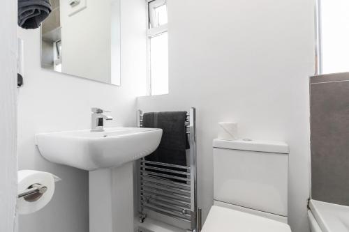 a white bathroom with a sink and a toilet at Stylish Studio Apt in Leeds in Headingley