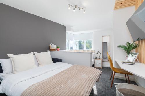海丁利Stylish Studio Apt in Leeds的一间卧室，配有一张床和一张带笔记本电脑的书桌