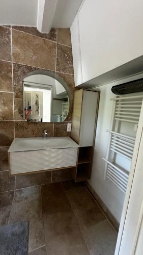 La salle de bains est pourvue d'une baignoire et d'un miroir. dans l'établissement Le Mas des oliviers, à Grimaud