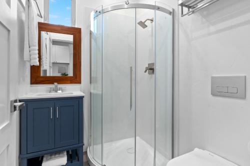 a bathroom with a glass shower with a blue cabinet at Miramar Oasis - Ocean View, Steps2Beach, Roof Deck in El Granada