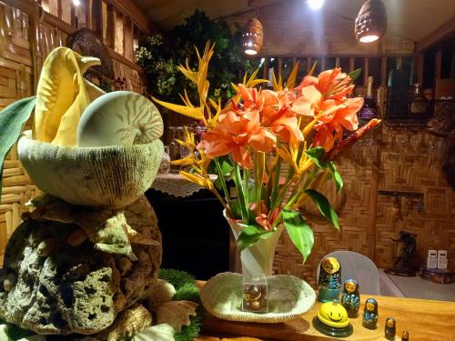 a vase filled with flowers on top of a table at Hidden Tourist Inn in Mambajao