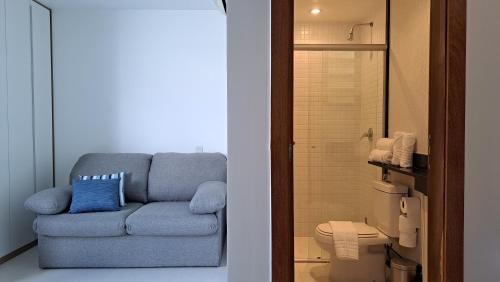 a blue couch in a bathroom with a shower at Athos Bulcão - Cobertura Duplex - Un 1519 in Brasilia