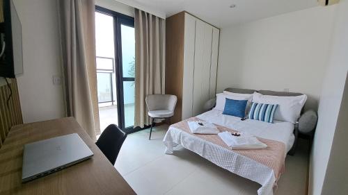 a bedroom with a bed and a desk with a laptop at Athos Bulcão - Cobertura Duplex - Un 1519 in Brasilia