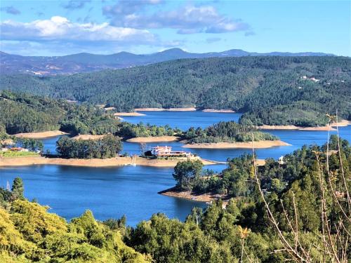 a view of a lake with trees and mountains at Quinta Pura Natura in Alqueidão de Santo Amaro