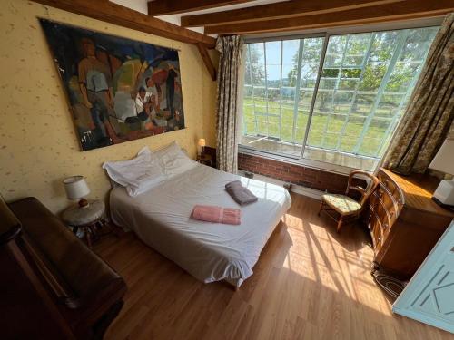 a bedroom with a white bed and a large window at Le Chesnoy 17 pers piscine tennis in Parly