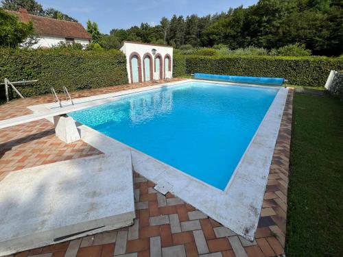 a swimming pool in a yard with a brick patio at Le Chesnoy 17 pers piscine tennis in Parly