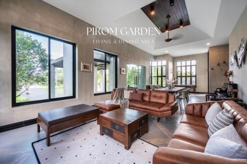 a living room with leather furniture and a table at Pirom Garden Private Villa in North Pattaya