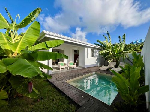un patio trasero con piscina y una villa en Villas Makandja - plage à 3 min à pied, piscines et jardins privés, en Sainte-Anne