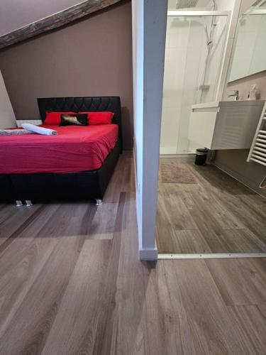 - une chambre avec un lit rouge et du parquet dans l'établissement Maison avec jardin proche gare, à Belleville-en-Beaujolais