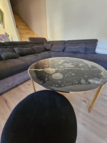 - un salon avec une table en verre devant un canapé dans l'établissement Maison avec jardin proche gare, à Belleville-en-Beaujolais