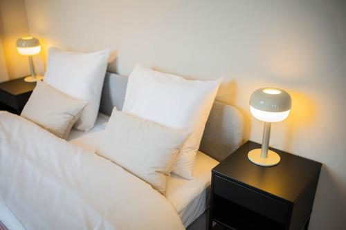 a white couch with pillows and a lamp on a table at Kerkstraat in Hilversum