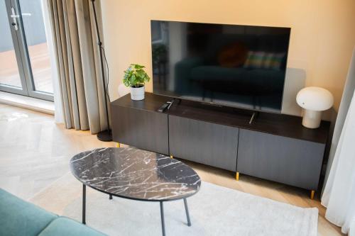 a living room with a tv and a coffee table at Kerkstraat in Hilversum